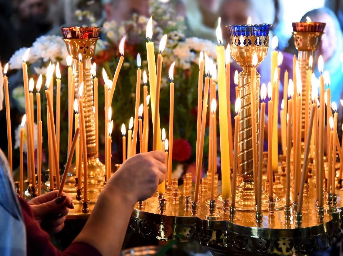 Ranks of lit beeswax candles in a church Ranks of lit beeswax candles in a church