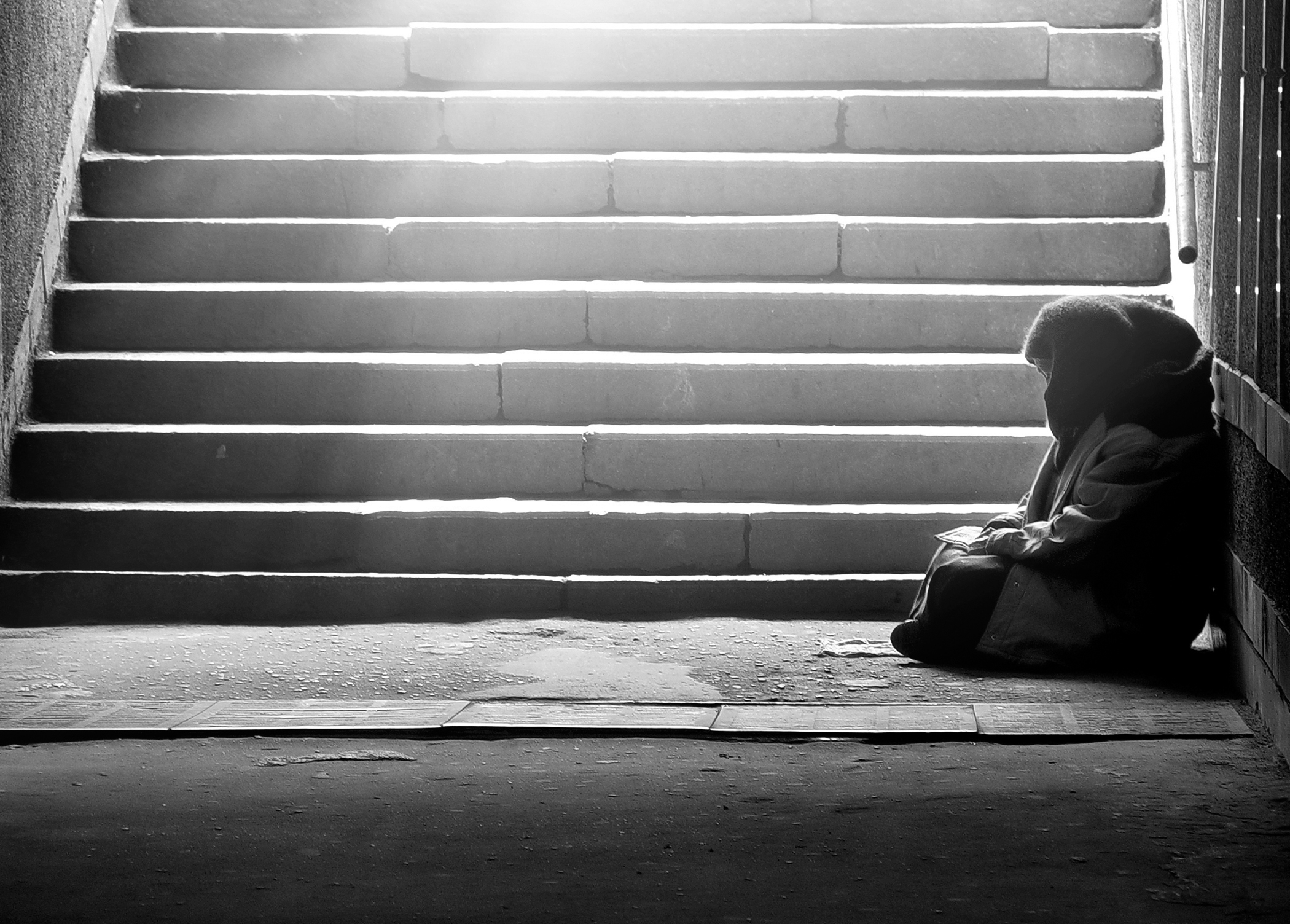 Homeless woman reading the book in subway under the sunlight Homeless woman reading the book in subway under the sunlight
