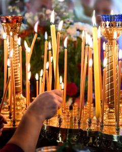 Ranks of lit beeswax candles in a church
